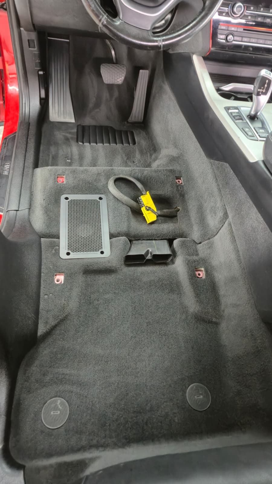 Aceeași podea, din același unghi, după extracție: mocheta e uniformă, fără resturi, iar difuzorul din podea și conectorul de airbag sunt curate.